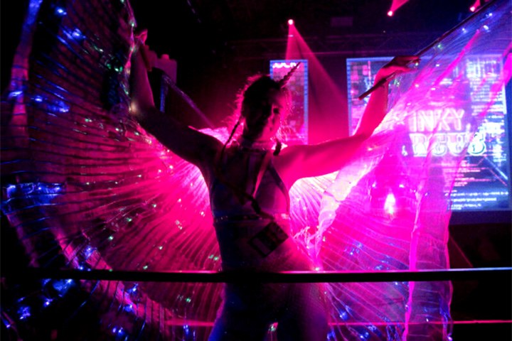 Frau vor pinkem Licht tanzt im Kinky Circus